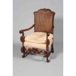 A CAROLEAN STYLE WALNUT ARMCHAIR, with double walled canework back and scroll feet.