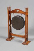 AN ARTS AND CRAFTS OAK DINNER GONG, with four square section columns, complete with beater,