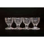 A SET OF FOUR CUT-GLASS SALTS, circa 1800, each with scalloped rim above a panelled body,