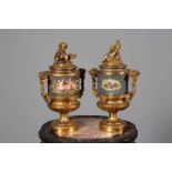 PAIR OF GILT-METAL URNS AND COVERS, each cover with the figure of a putti,