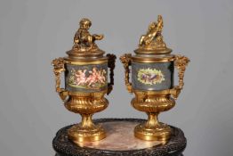 PAIR OF GILT-METAL URNS AND COVERS, each cover with the figure of a putti,