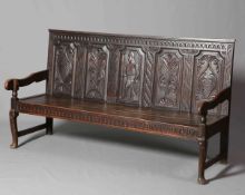 A LATE GEORGIAN OAK SETTLE, with later carved five panel back of a soldier and foliage,