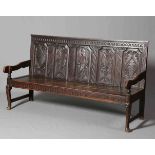 A LATE GEORGIAN OAK SETTLE, with later carved five panel back of a soldier and foliage,