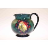 A WILLIAM MOORCROFT POTTERY JUG IN THE LEAF AND BERRIES PATTERN, of globular form,
