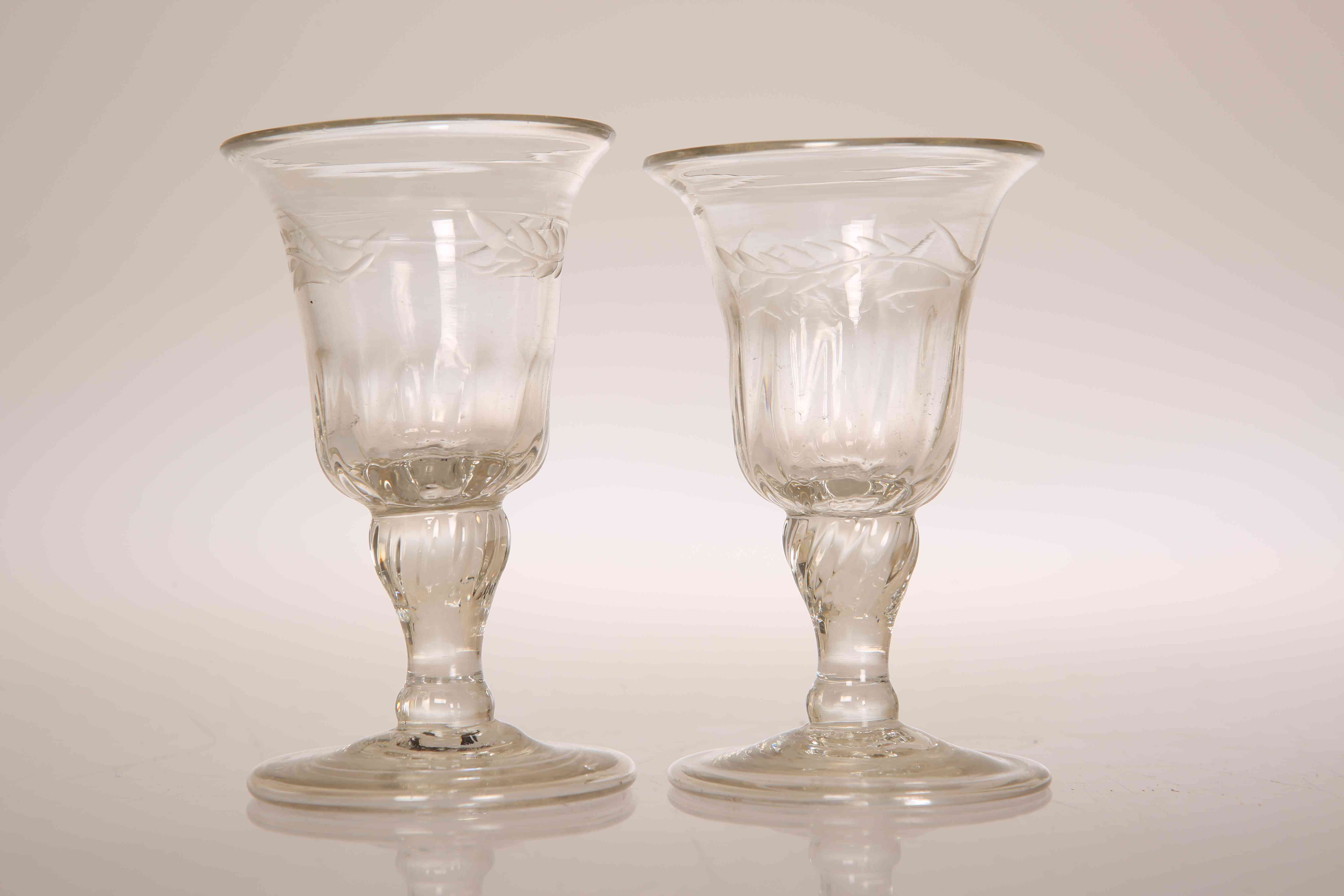 A PAIR OF GEORGIAN FOLDED FOOT GIN GLASSES, with bell bowls cut with leaves.