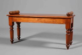 A MAHOGANY WINDOW SEAT IN WILLIAM IV STYLE, raised on reeded legs.