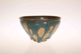 A CHINESE GREEN GLAZED POTTERY BOWL IN THE SUNG STYLE, mottled glazed with unglazed foot.