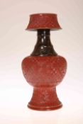 A CHINESE PORCELAIN CANDLE HOLDER, glazed and moulded to simulate cinnabar lacquer,