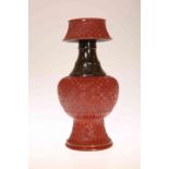 A CHINESE PORCELAIN CANDLE HOLDER, glazed and moulded to simulate cinnabar lacquer,