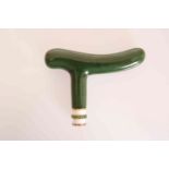 A NEPHRITE JADE, ENAMEL AND DEMANTOID GARNET SET CANE HANDLE, IN THE MANNER OF FABERGE.