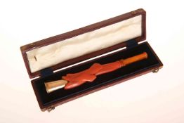 A LATE 19th CENTURY CARVED CORAL AND AMBER CHEROOT HOLDER, with ring-turned amber mouthpiece,