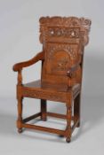 A 17TH CENTURY STYLE CARVED OAK WAINSCOT CHAIR, with planked seat and scroll carved crest.
