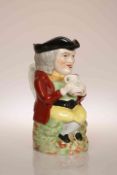 A 19TH CENTURY TOBY JUG, modelled and painted wearing red jacket and holding a jug with both hands,