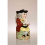 A 19TH CENTURY TOBY JUG, modelled and painted wearing red jacket and holding a jug with both hands,