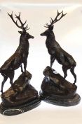 Large modern pair of bronze stags on rocky outcrops mounted on marble plinths,