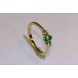 18 carat yellow gold oval emerald and round brilliant diamond three stone ring