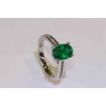 18 carat gold oval Zambian emerald and channel set round brilliant diamond shoulder ring,