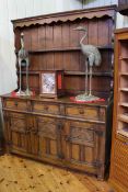 Carved oak dresser with shelf back above three drawers and three cupboard doors,