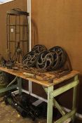 Collection of vintage ironwork including two water pumps, pulley wheel, shoe lasts,