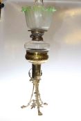 Ornate brass based oil lamp with glass reservoir and etched green tinted shade