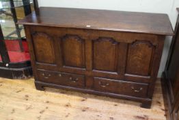 Antique oak mule chest having fielded arched panel front above two drawers on shaped bracket feet,