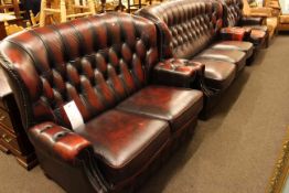 Ox blood deep buttoned leather and studded three seater settee and pair of two seater settees