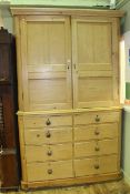 Victorian pine press having two panelled doors above two banks of four drawers,