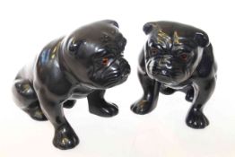 Two black glazed pottery models of seated bulldogs, 13.