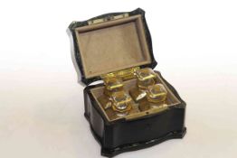 Four gilt mounted smelling salts bottles in serpentine sided casket