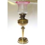 Brass column oil lamp with ruby tinted etched glass shade