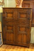 Carved oak four door cabinet with strap hinges,