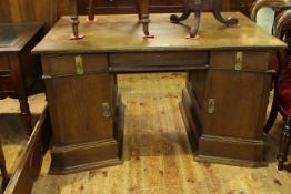 Arts & Crafts oak pedestal desk having three inverted frieze drawers above two inverted cupboard