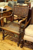 Carved oak armchair with buttoned hide panel back and seat