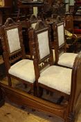 Set of four carved oak dining chairs with fabric panel backs