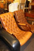 Two buttoned leather scroll armchairs