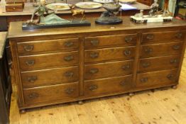 Period style oak twelve drawer dresser on bun feet,
