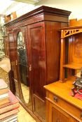 Edwardian mahogany and string inlaid triple door wardrobe having central oval mirror,