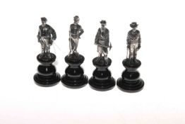 Four white metal male figures