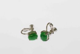 Pair of jadeite earrings, each oval cut jadeite four claw set on screw back fittings,