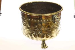 Highly polished embossed brass log bin with lion mask handles,
