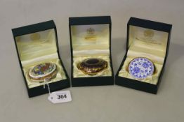 Toye, Kenning & Spencer enamel pill box; together with two paperweights in Toye,