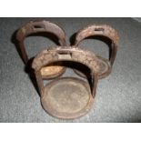 THREE CHINESE IRON STIRRUPS, 19TH CENTURY with oval tread, arched sidebars rising to a pierced