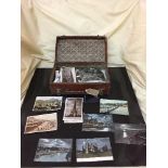 A small vintage leather case containing assorted black and white monochrome postcards and a Van