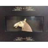 A ceramic horse head in a oriental style frame