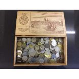 A wooden cigar box containing copper and silver coinage of the world