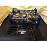 A basket of assorted stainless steel and silver plated cutlery