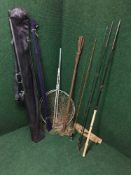 A fishing rod bag containing four assorted fishing rods and two landing nets