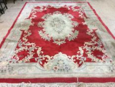 A large fringed Chinese rug on red ground approx.