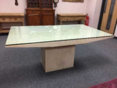A marble dining table on pedestal base with plate glass top,