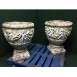 A large pair of stone classical garden planters with cherub decoration on stands